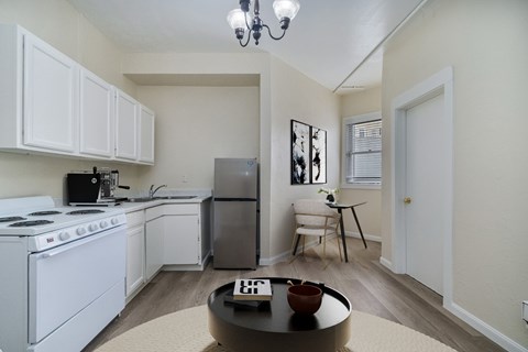 A kitchen with white cabinets and a stove top oven.
