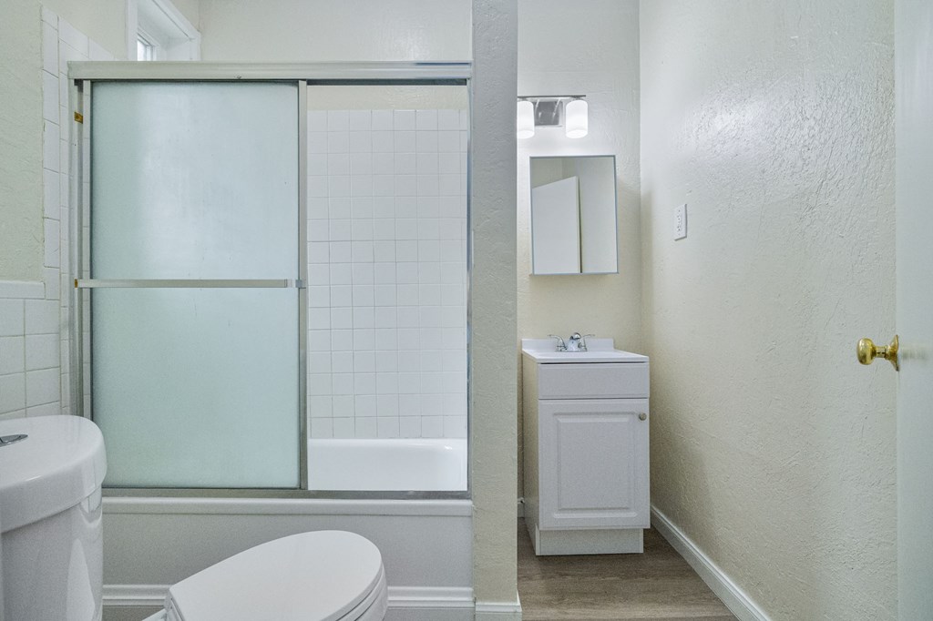 A white toilet sits next to a white sink in a bathroom.