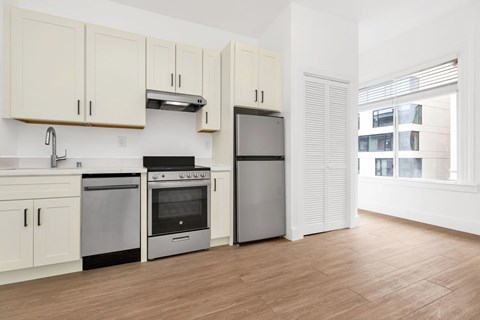 A kitchen with white cabinets and stainless steel appliances.