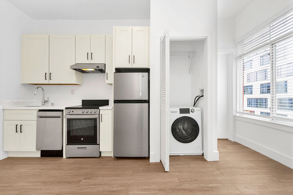 A kitchen with white cabinets and a stainless steel refrigerator.