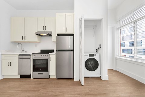 A kitchen with white cabinets and a stainless steel refrigerator.