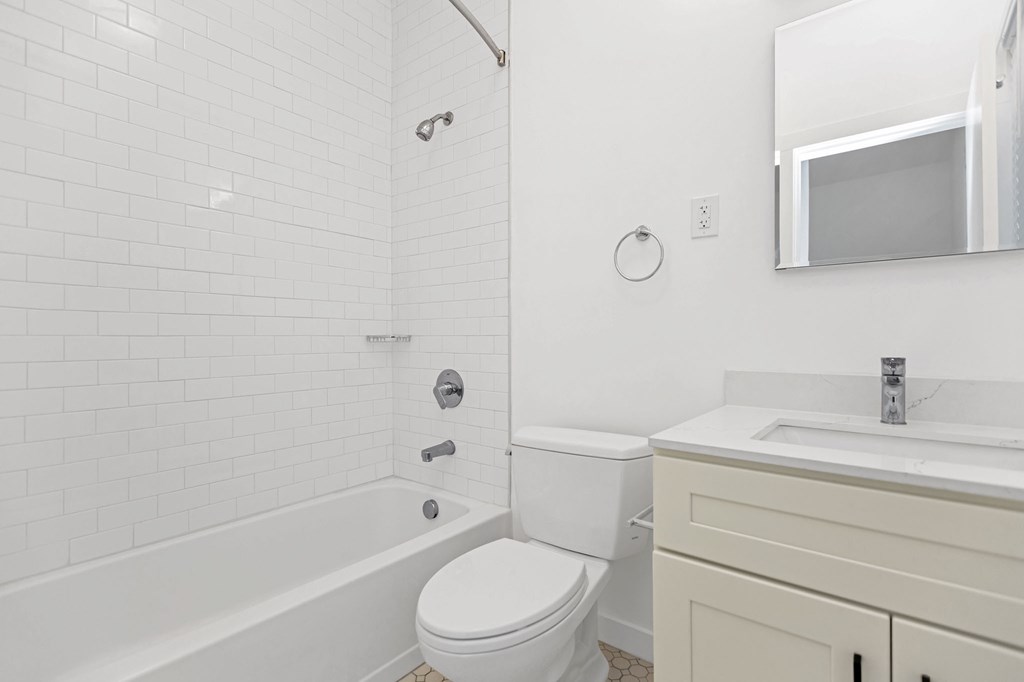 A white bathroom with a toilet, sink, and tub.
