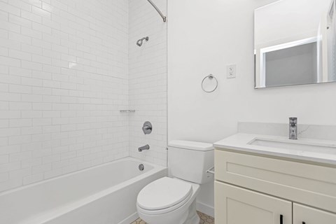 A white bathroom with a toilet, sink, and tub.