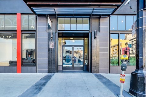 A modern building with a glass entrance and a red column on the left.