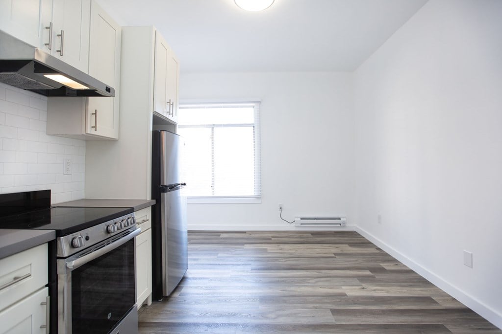 A kitchen with a black stove top oven and white cabinets.