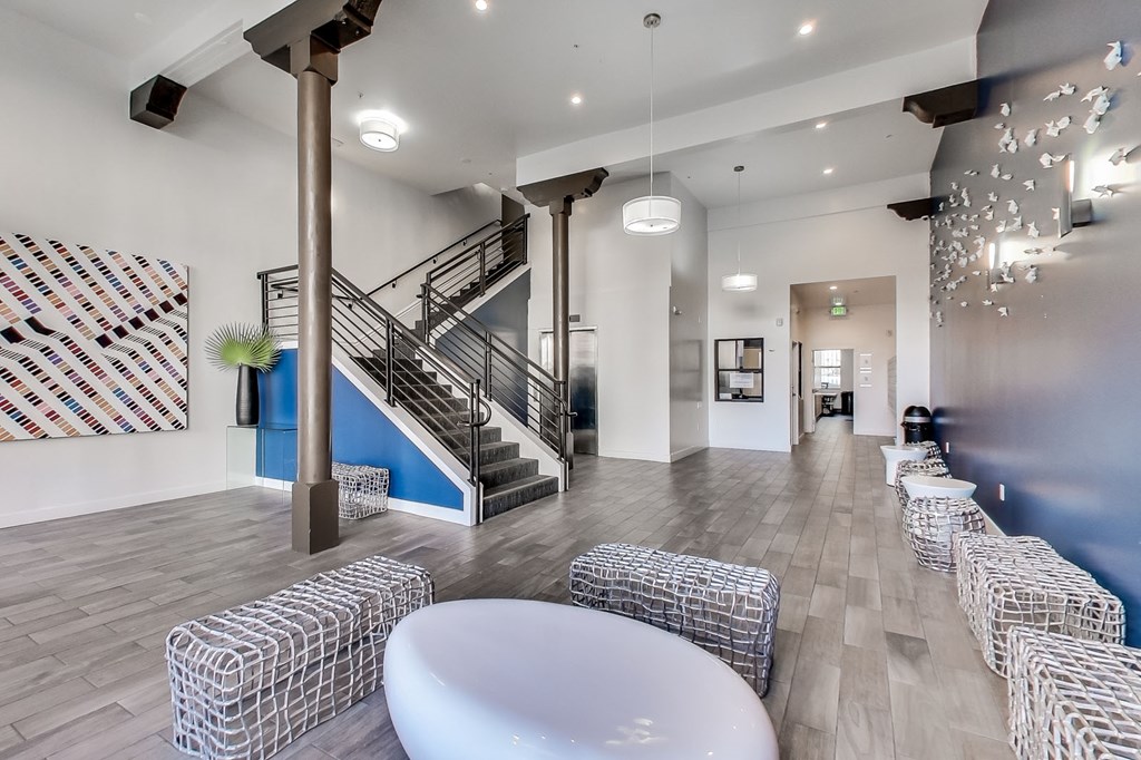 A white table is in the middle of a room with a staircase.