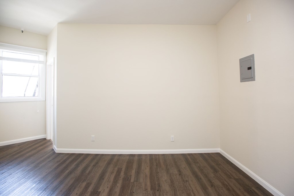 Empty room with wooden floors and a window.