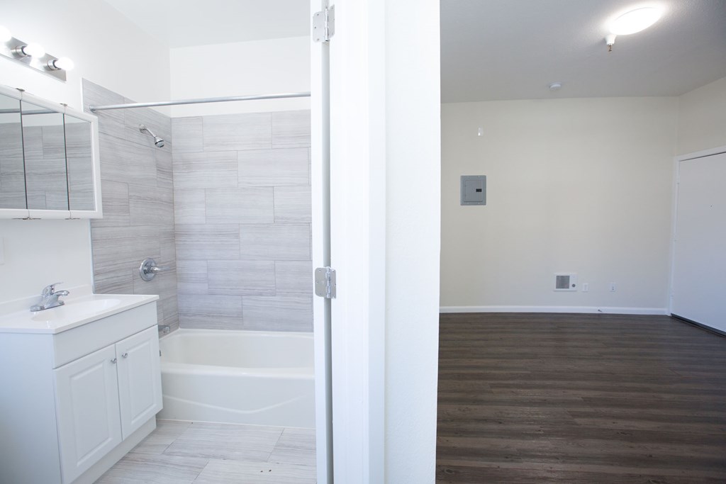 A bathroom with a white tub and sink.