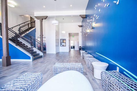 A blue wall with a staircase and a white chair.