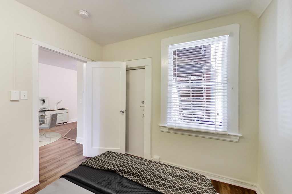 a bedroom with a bed and a window and a door to a bathroom