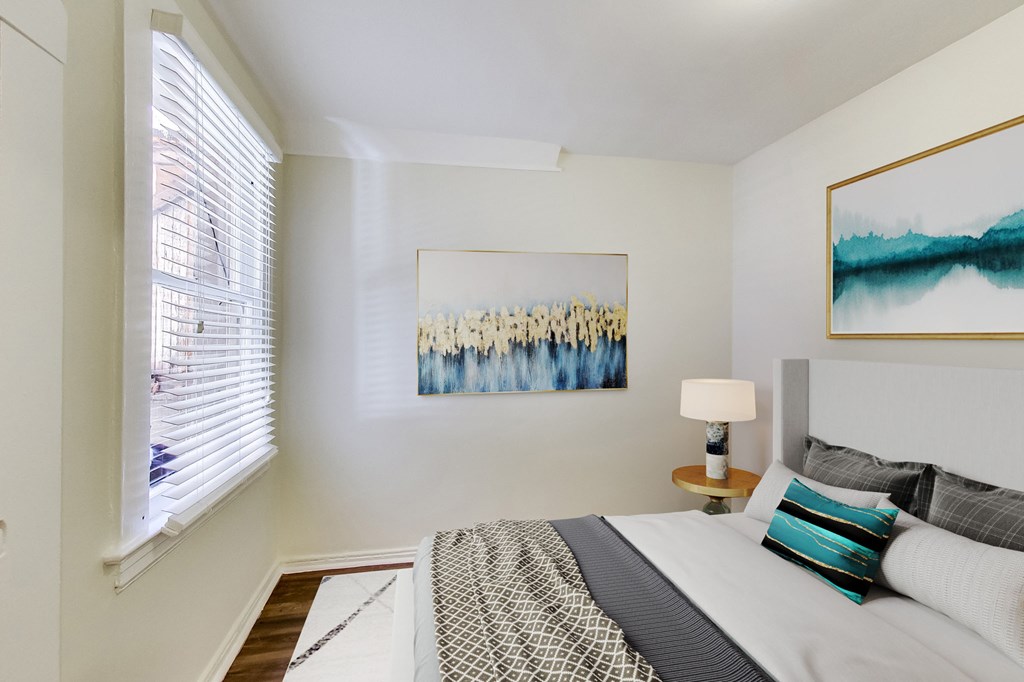 a bedroom with a bed and a window with blinds