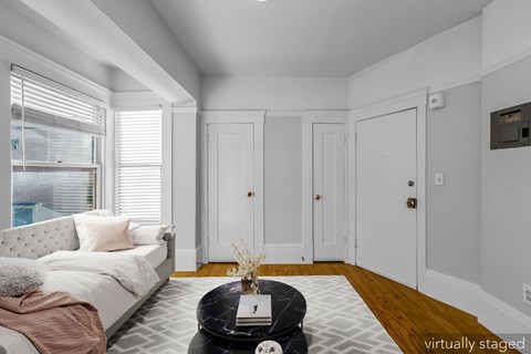 A living room with a couch, coffee table, and three doors.