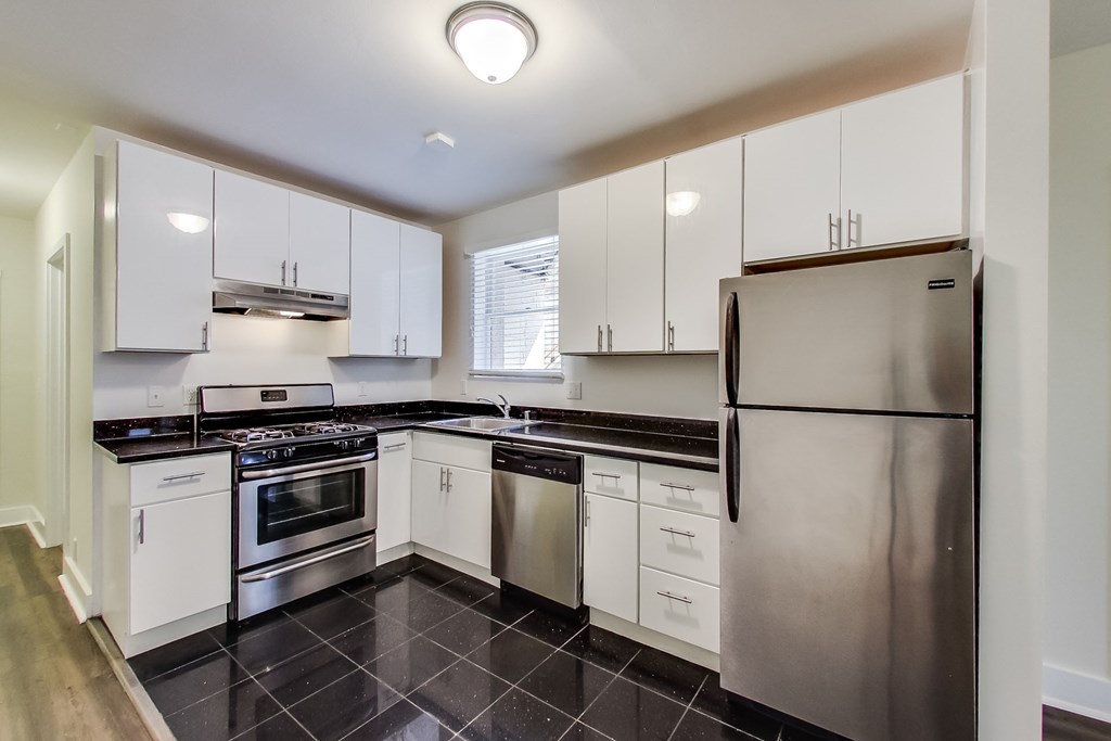 a kitchen with white cabinets and stainless steel appliances