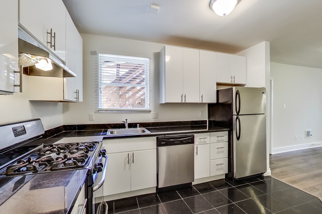 a kitchen with stainless steel appliances and white cabinets