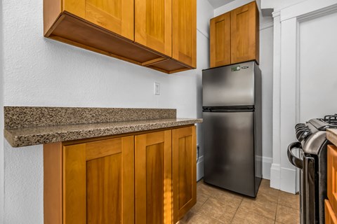 A kitchen with wooden cabinets and a granite countertop.