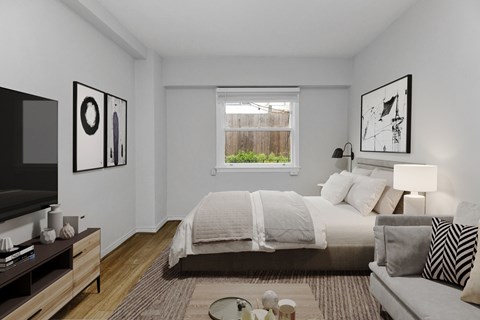 A bedroom with a bed, a couch, a television, and pictures on the wall.