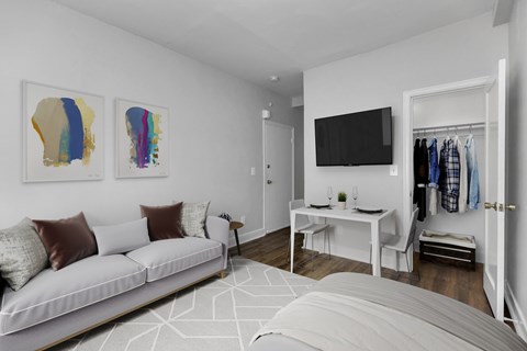 A living room with a white couch and two abstract art pieces on the wall.