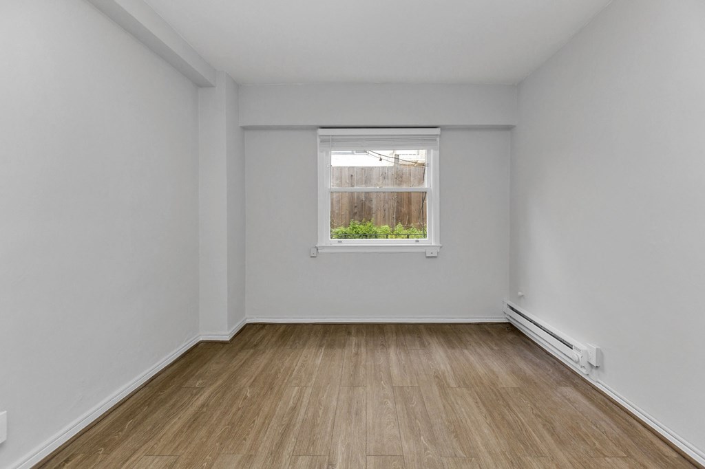 an empty room with white walls and a window