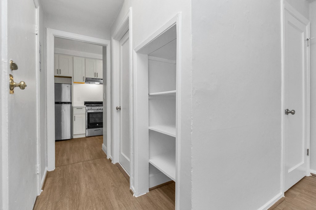 a bedroom with white walls and a closet with open doors