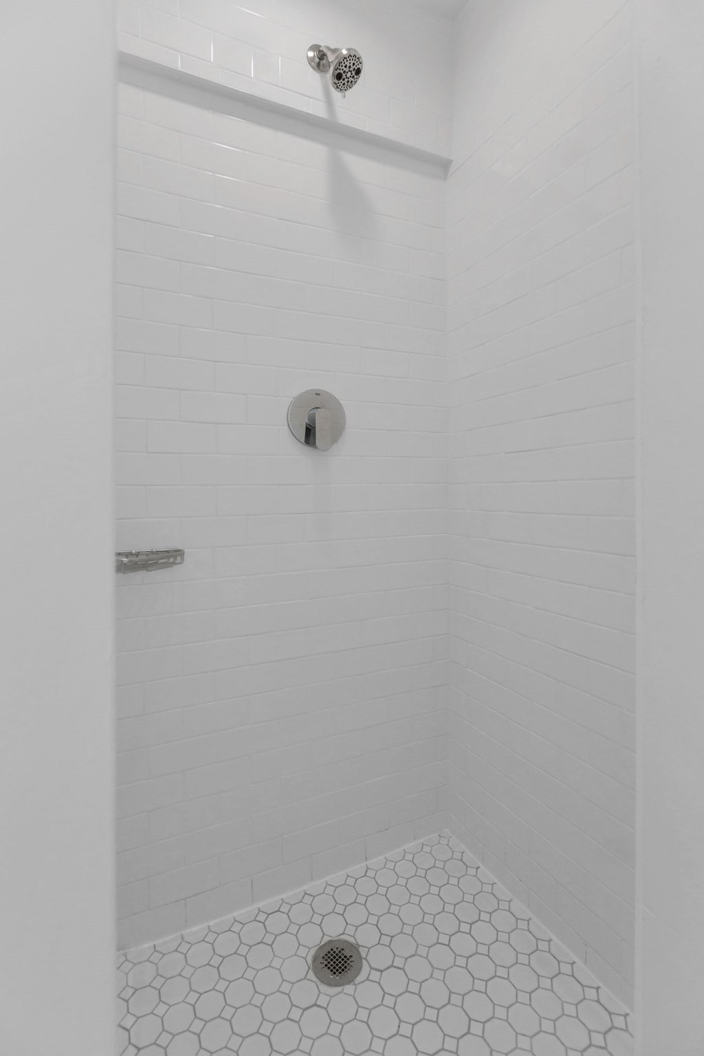 a white tiled shower in a white bathroom