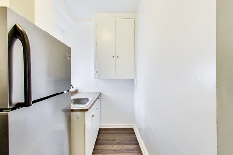 A kitchen with a refrigerator and a cabinet.