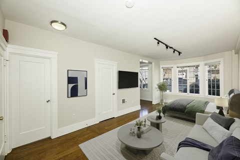 A living room with a couch, coffee table, and a painting on the wall.