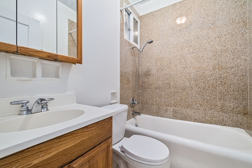 A bathroom with a white toilet, a white sink, and a white bathtub.