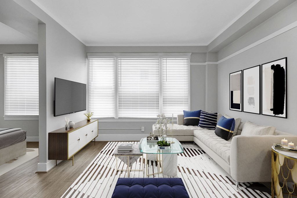 A modern living room with a white couch, a coffee table, and a television.