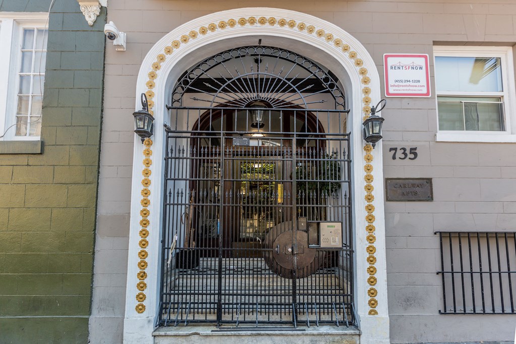 A gate with a sign that says "Rentshon" is in front of a building.