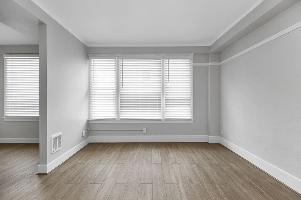 A room with wooden flooring and white walls.