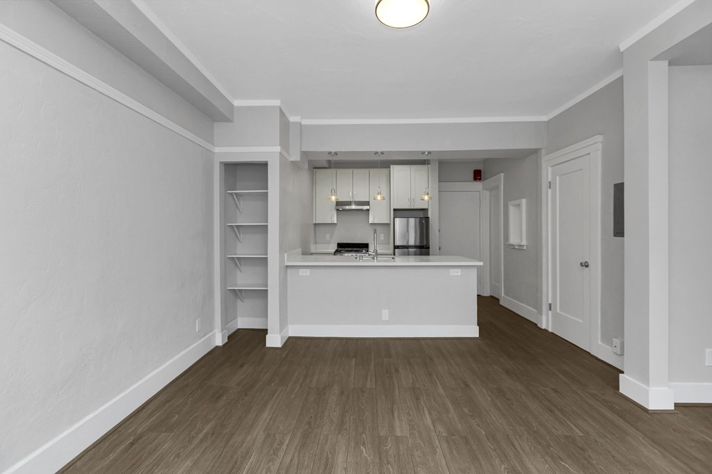 A kitchen area with a white counter and cabinets.