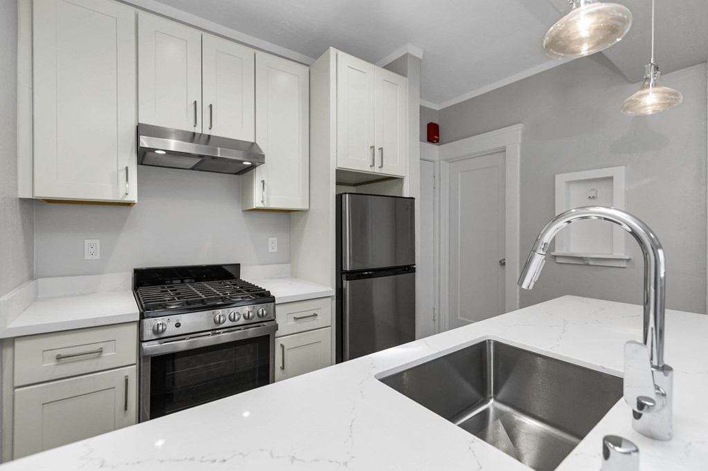 A kitchen with white cabinets and a black stove top oven.