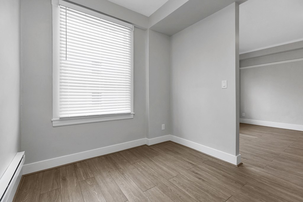 A room with a window and wooden flooring.
