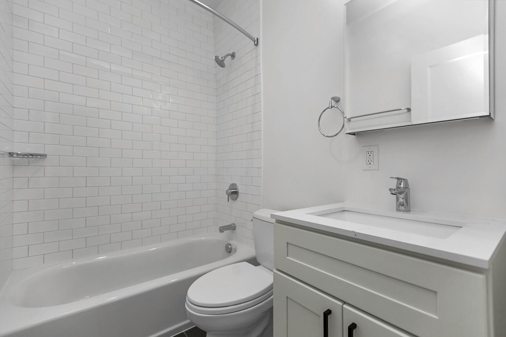 A white bathroom with a toilet, sink, and bathtub.
