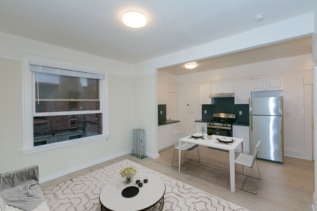 A white kitchen with a table and chairs.