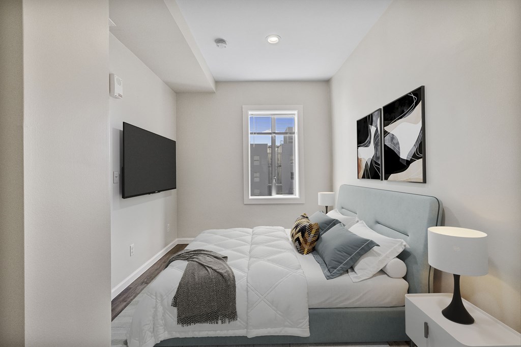 A bedroom with a bed, a lamp, a window and a painting on the wall.