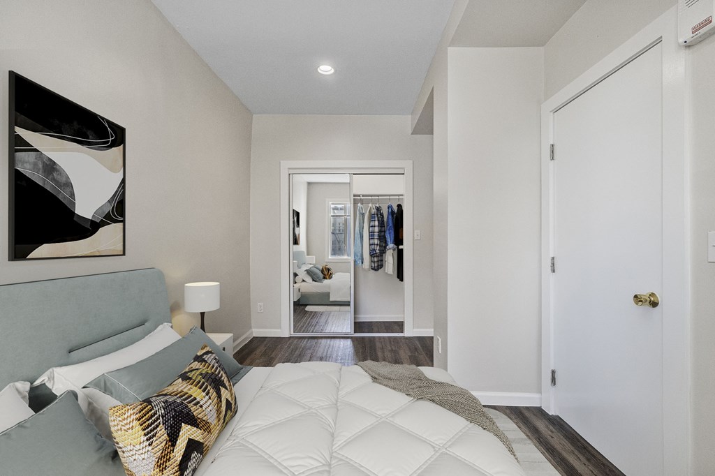 A bedroom with a large bed and a painting on the wall.