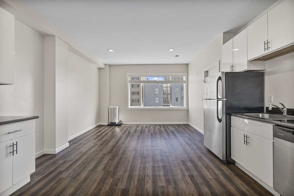 A kitchen with white cabinets and a black countertop.