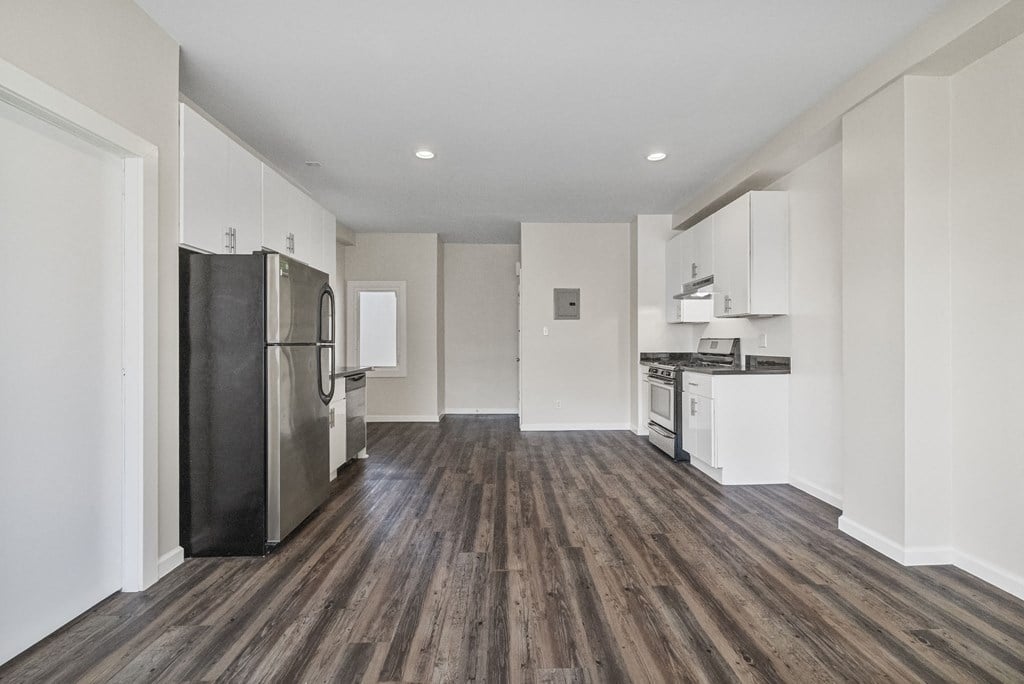 A kitchen with a refrigerator, oven, and sink.