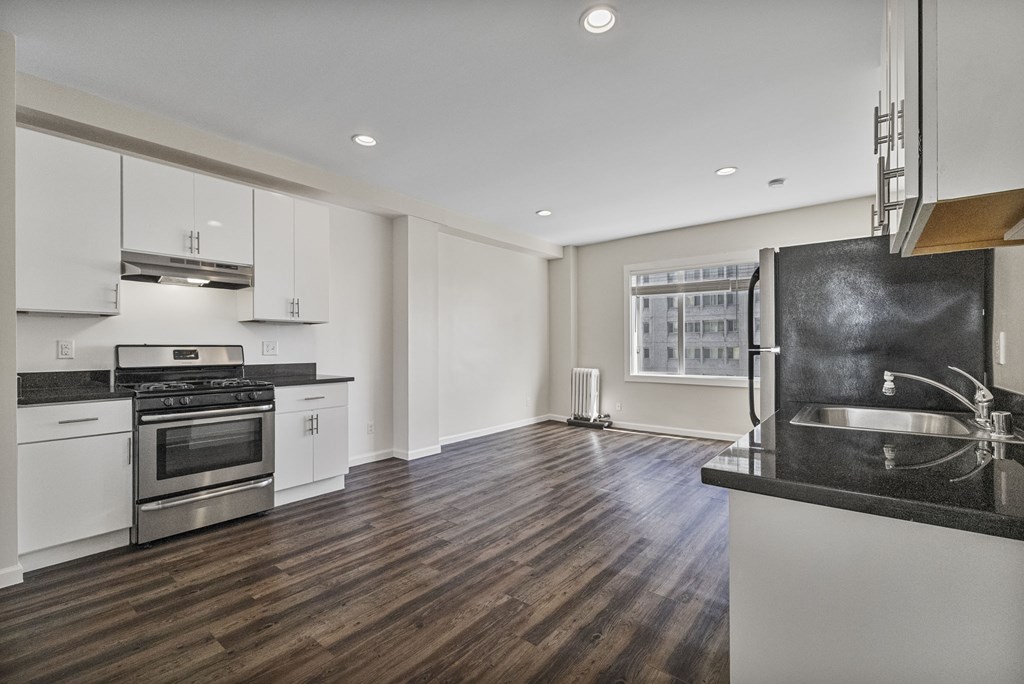 A modern kitchen with a stainless steel oven and wooden floors.