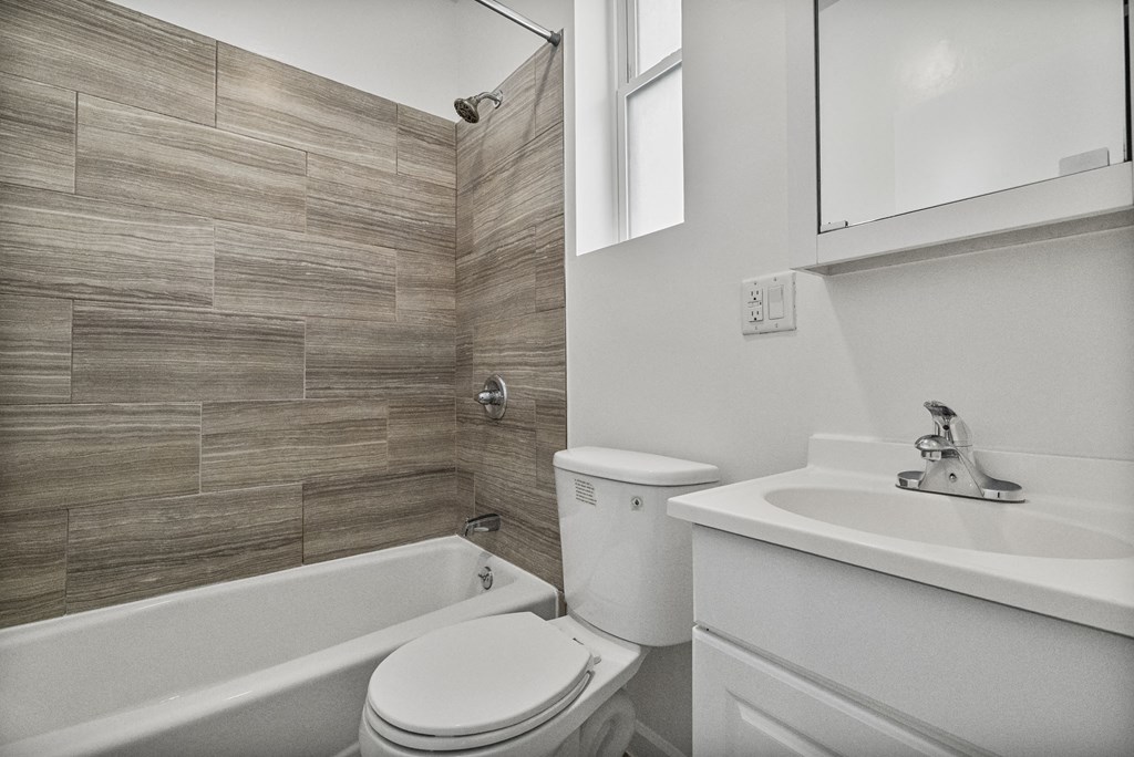 A white toilet sits next to a white sink in a bathroom.