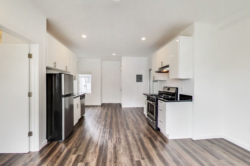a renovated kitchen with white cabinets and a black stove and refrigerator