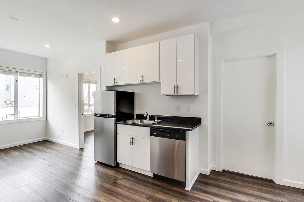 a kitchen with white cabinets and a stainless steel refrigerator