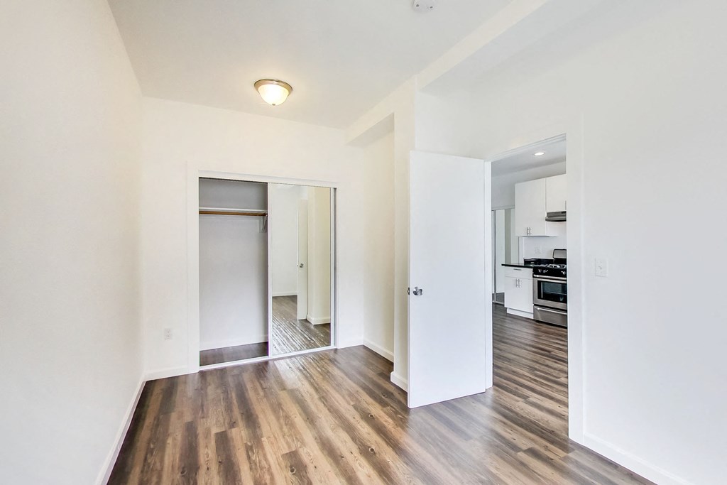 a renovated living room with white walls and wood floors