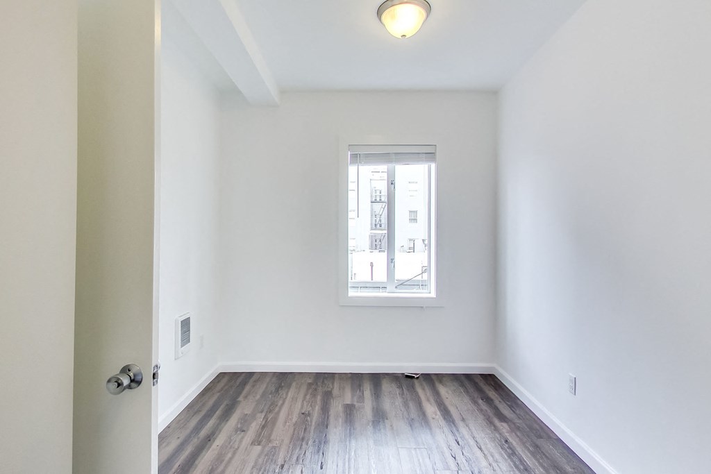an empty room with white walls and a window