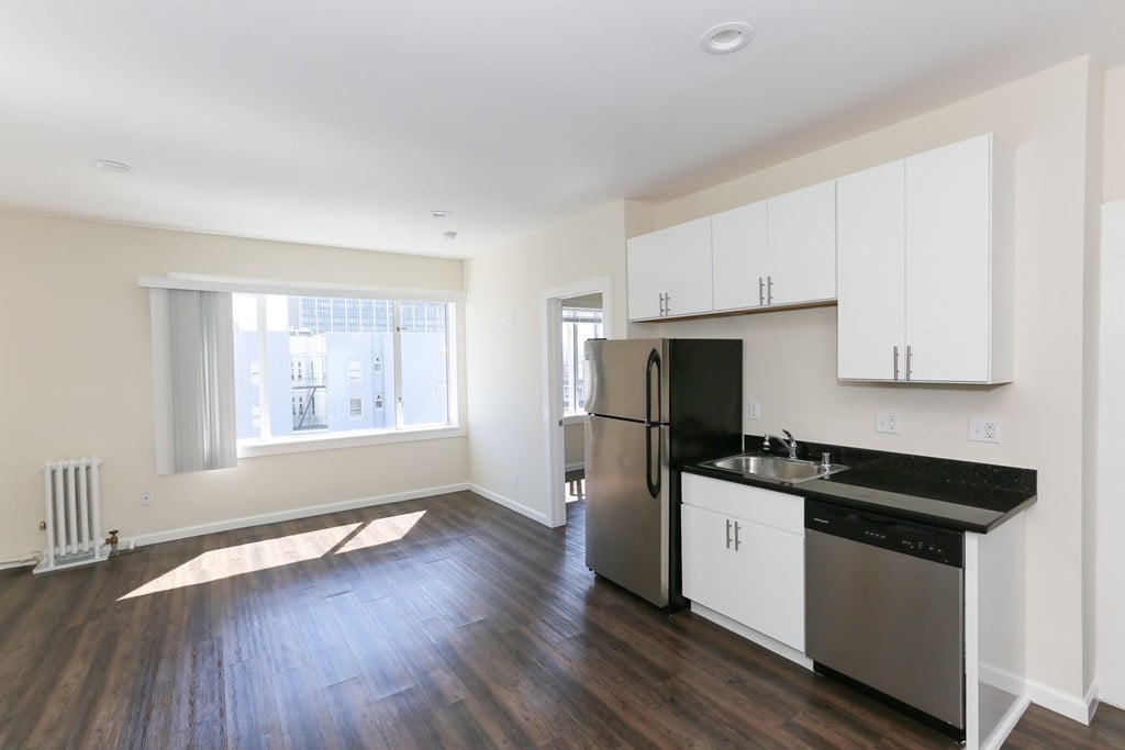 A kitchen with a black countertop and stainless steel appliances.