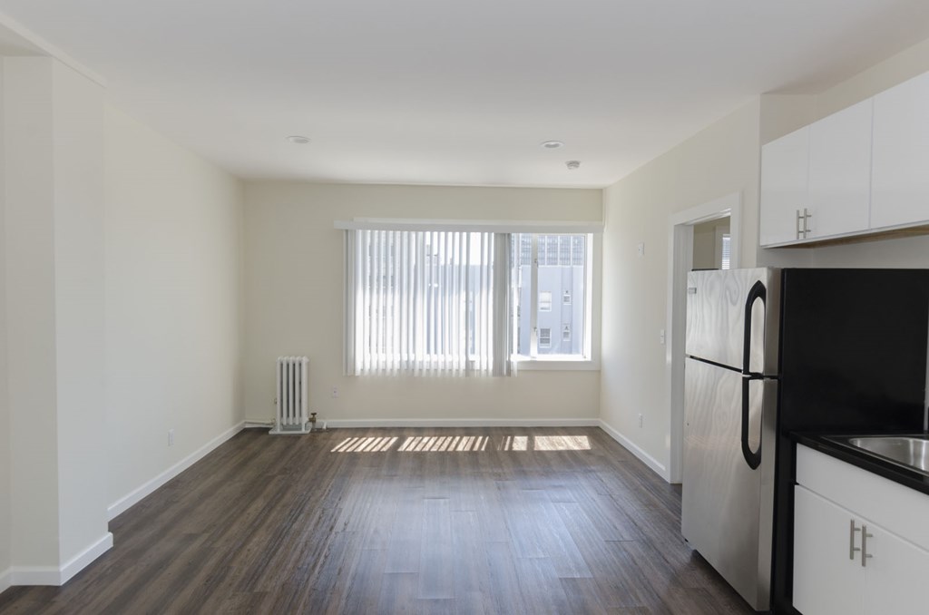 A kitchen with a black fridge and white cabinets.