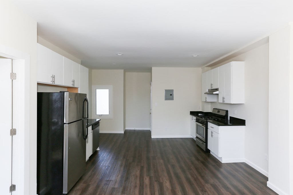 A kitchen with black appliances and white cabinets.