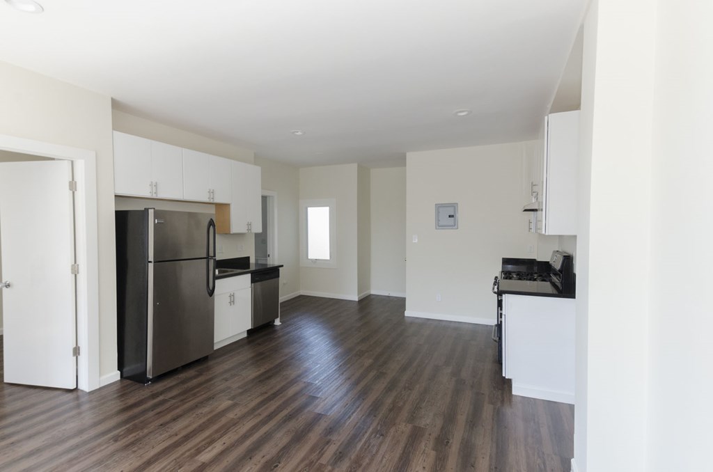 A kitchen with a refrigerator, microwave, and oven.