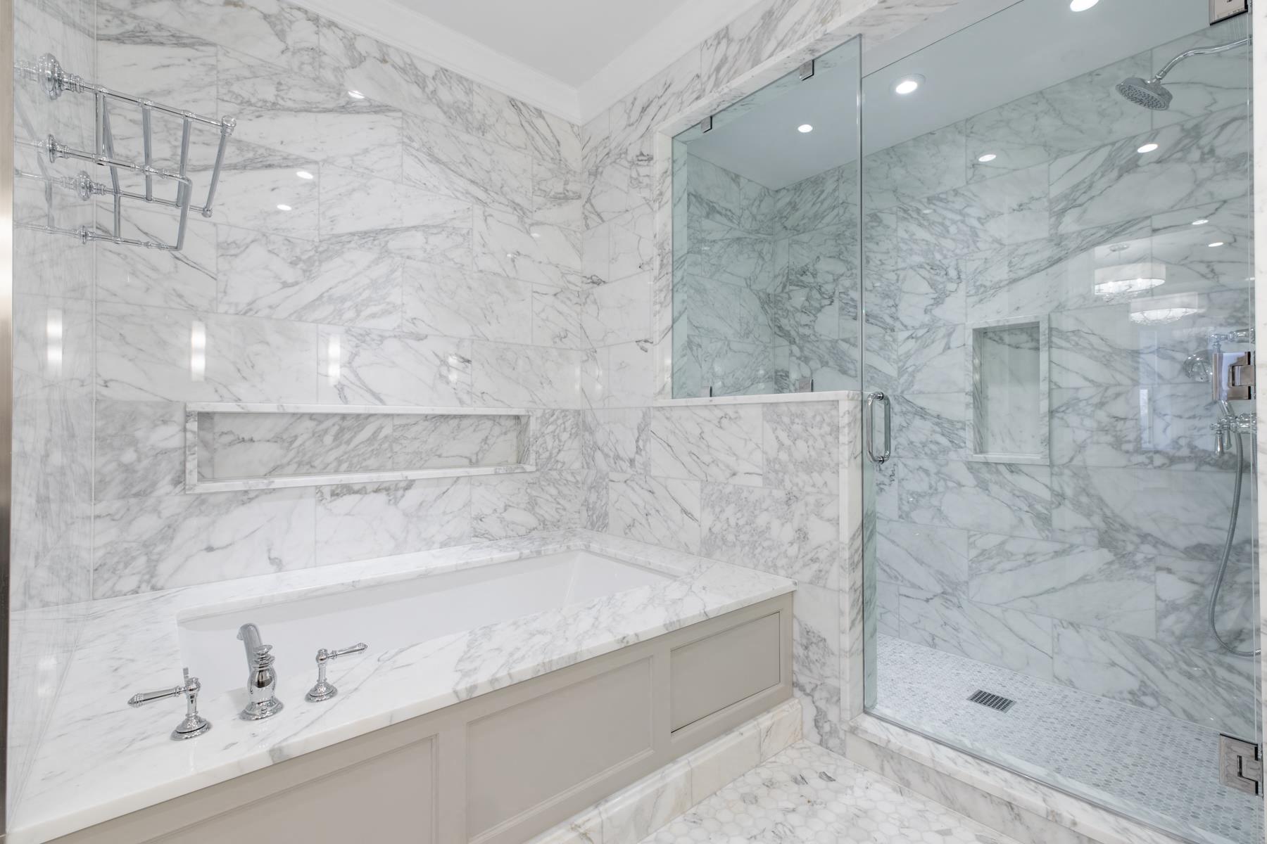 a marble bathroom with a tub and a shower